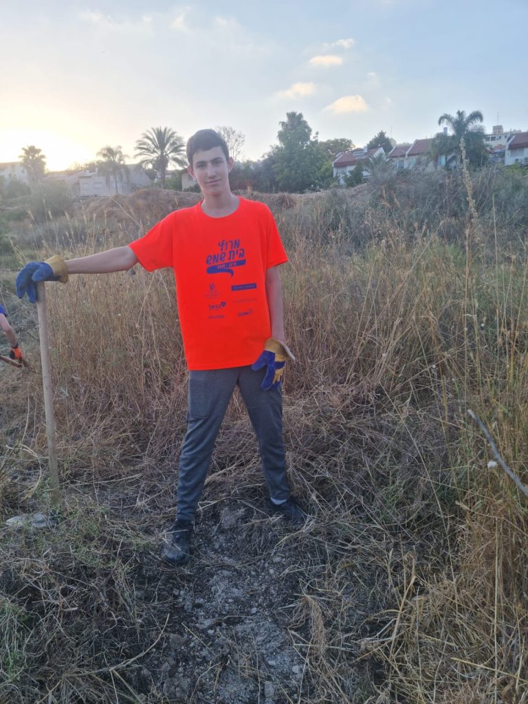 Young man with hoe proudly clearing path